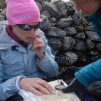 Taking instruction from Lou Tully in taking a bearing at the cairn at Carnedd Dafydd (Emily Pitts)