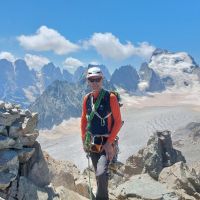 Steve Graham summits Pic du Glacier Blanc via S. Ridge (D-), Pelvoux and Barre des Ecrins the backdrop (Andy Stratford)